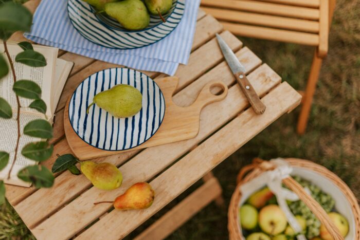 A wooden table topped with bowls of fruit